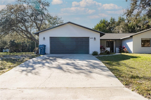 ranch-style house featuring an attached garage, driveway, a shingled roof, and a front yard