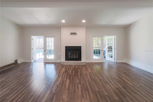 unfurnished living room with dark wood-style floors, french doors, and baseboards