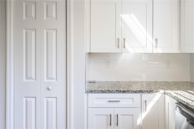 kitchen with tasteful backsplash, white cabinets, and stainless steel dishwasher