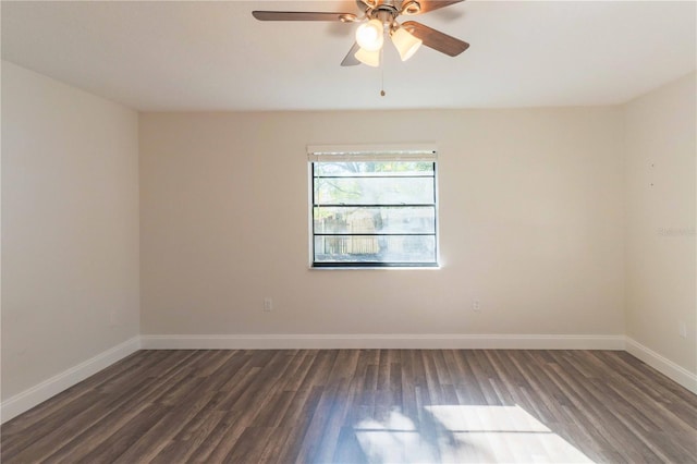 spare room with baseboards and wood finished floors