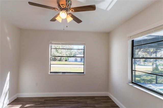 empty room with plenty of natural light, dark wood finished floors, and baseboards