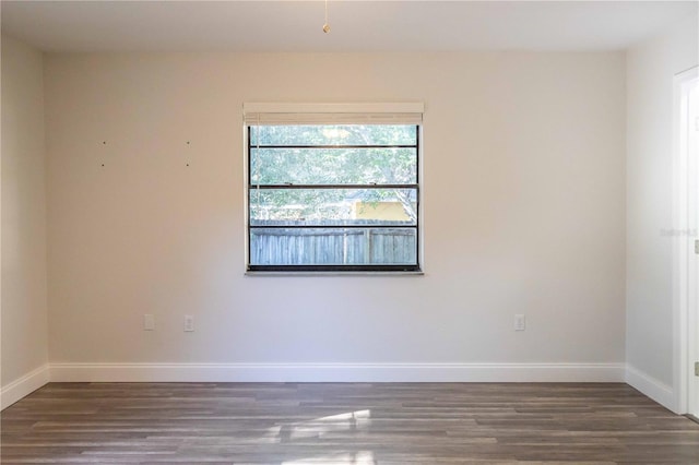 unfurnished room featuring baseboards and wood finished floors