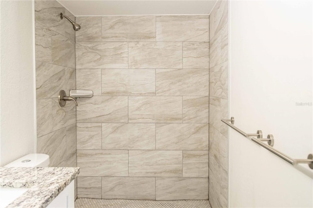 bathroom with a tile shower and vanity