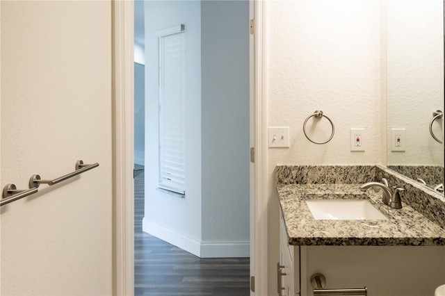 bathroom featuring vanity, baseboards, and wood finished floors