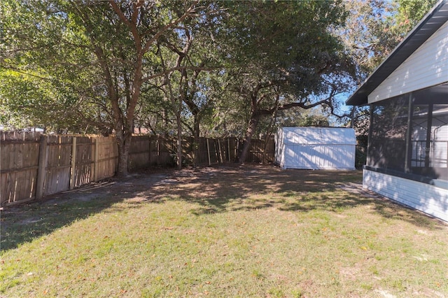 view of yard featuring a storage unit, an outdoor structure, and a fenced backyard