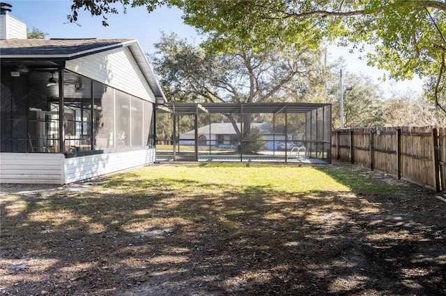 view of yard featuring a carport, a pool, glass enclosure, and a fenced backyard