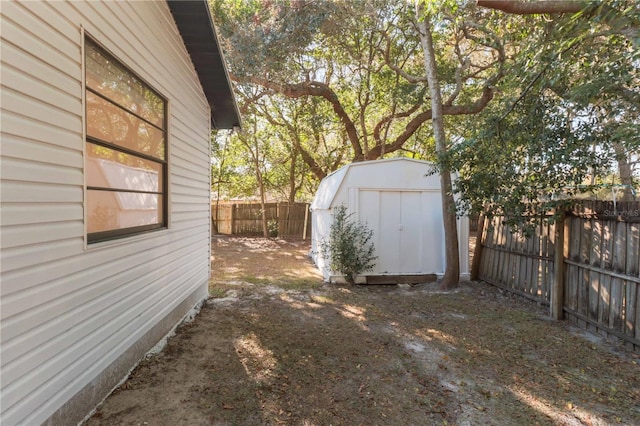 view of yard with an outbuilding, a fenced backyard, and a shed