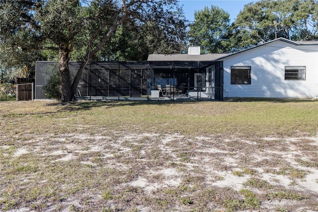 back of property featuring a chimney and a lawn