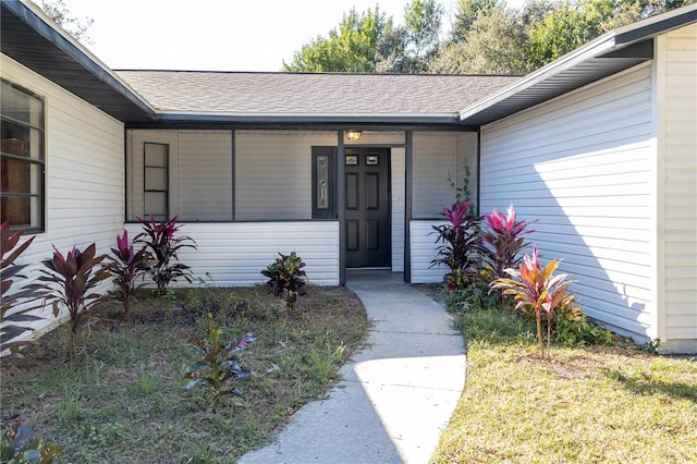 entrance to property featuring roof with shingles