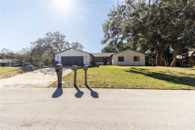 ranch-style house featuring driveway, a front lawn, and an attached garage