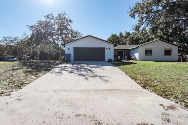 ranch-style home featuring a garage, driveway, and a front lawn