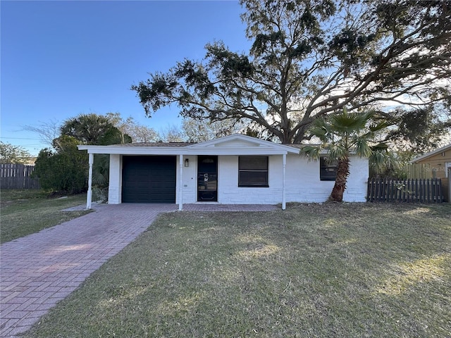 ranch-style house featuring a front lawn, decorative driveway, an attached garage, and fence