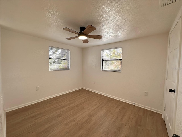 unfurnished bedroom featuring multiple windows, visible vents, and wood finished floors