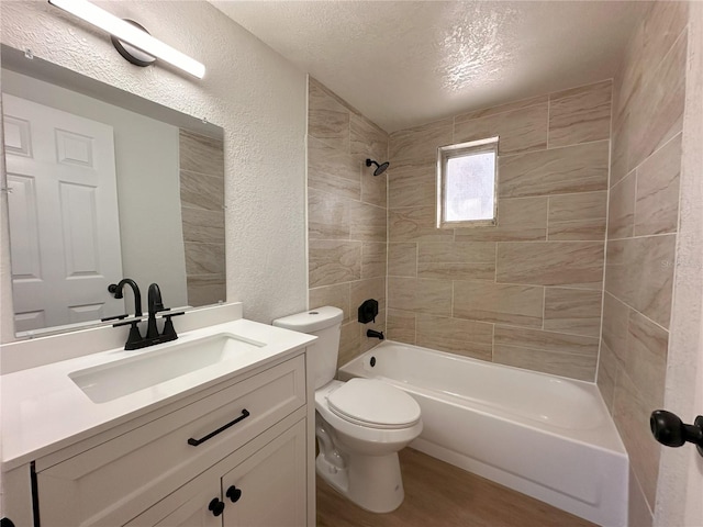 full bath featuring a textured ceiling, a textured wall, toilet, wood finished floors, and vanity