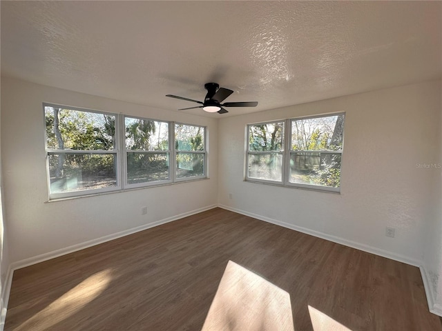 spare room featuring ceiling fan, a textured ceiling, baseboards, and wood finished floors