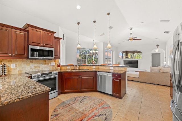 kitchen with appliances with stainless steel finishes, sink, vaulted ceiling, stone counters, and hanging light fixtures