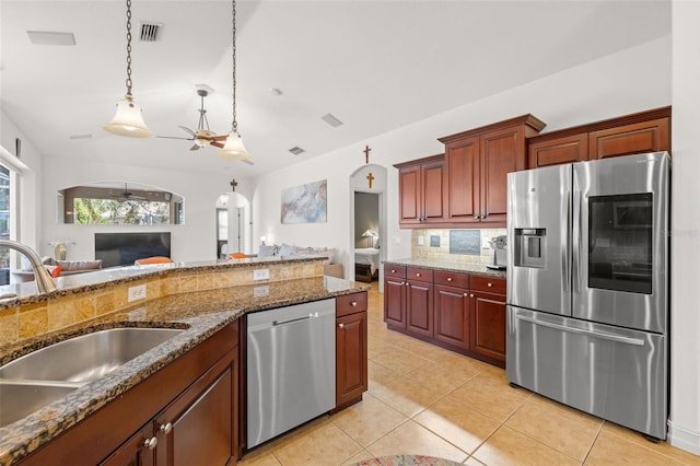 kitchen featuring tasteful backsplash, stainless steel appliances, decorative light fixtures, light tile patterned floors, and sink