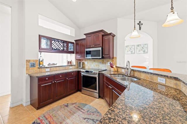 kitchen with stainless steel appliances, dark stone counters, decorative light fixtures, backsplash, and sink