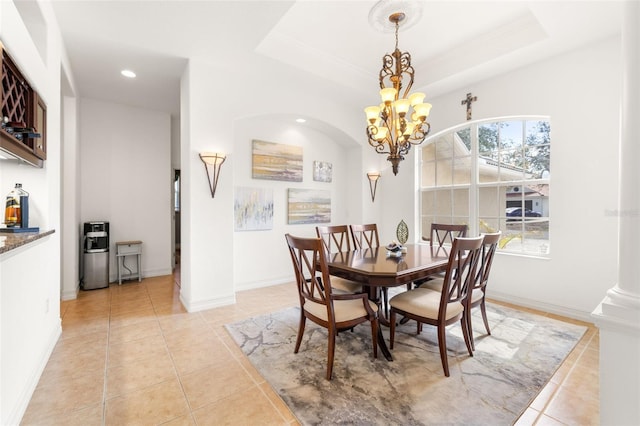 dining space featuring an inviting chandelier, a wealth of natural light, and a raised ceiling