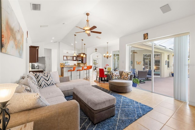 tiled living room featuring ceiling fan with notable chandelier and vaulted ceiling