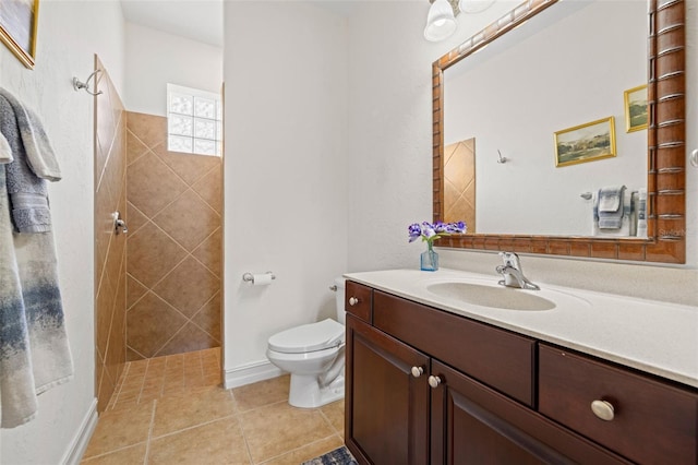 bathroom with toilet, tiled shower, tile patterned floors, and vanity