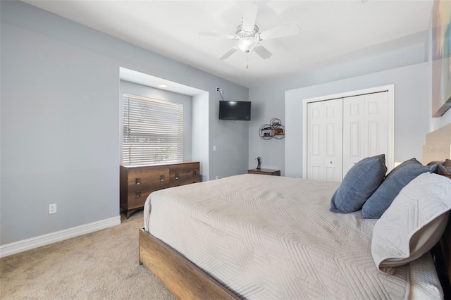 bedroom featuring ceiling fan, a closet, and light colored carpet