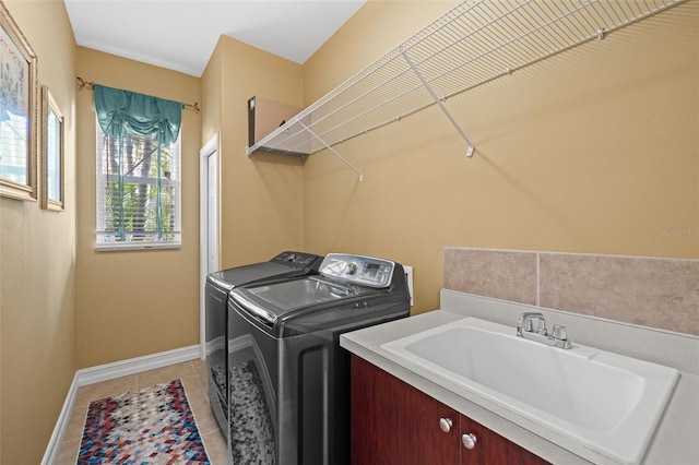 washroom with light tile patterned flooring, sink, and washing machine and clothes dryer