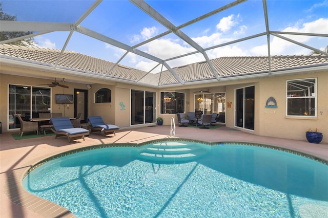 view of swimming pool featuring a patio area, ceiling fan, and glass enclosure