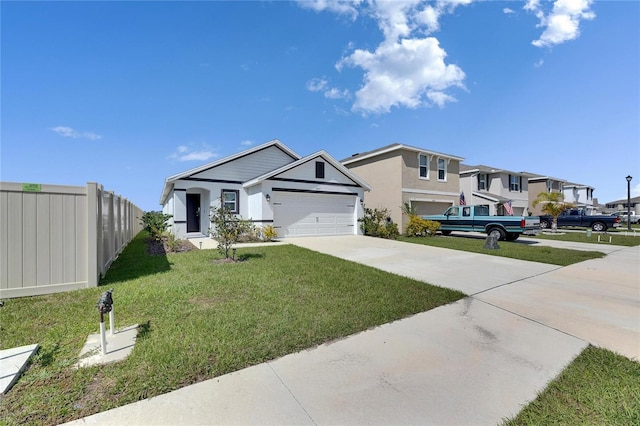 view of front of property with an attached garage, a front yard, fence, a residential view, and driveway