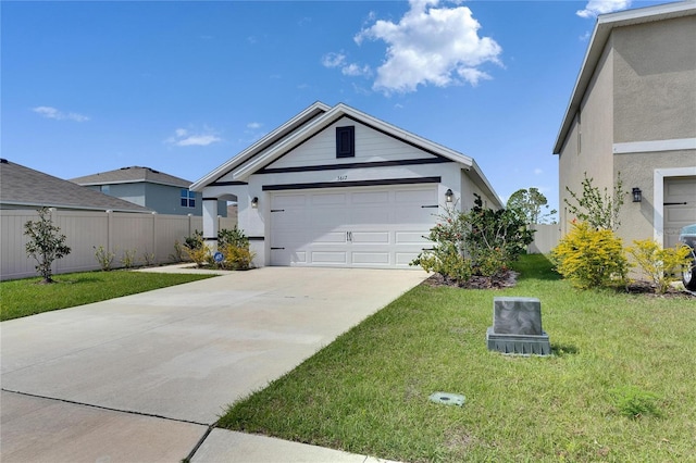 view of front of home featuring an attached garage, fence, concrete driveway, stucco siding, and a front lawn