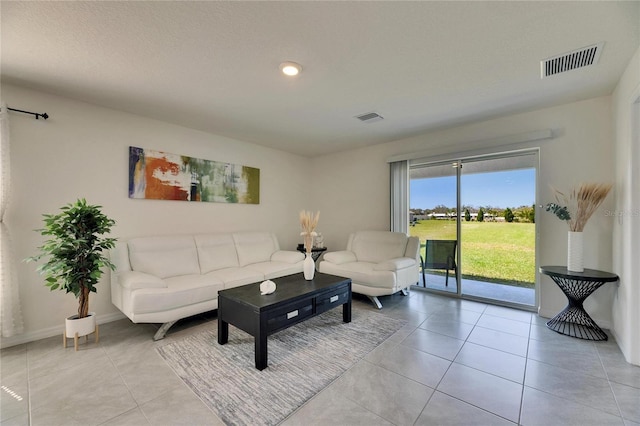 living area featuring baseboards, visible vents, and light tile patterned flooring