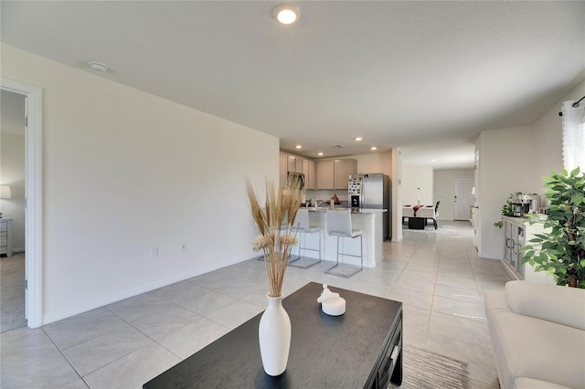 living area with light tile patterned floors, baseboards, and recessed lighting