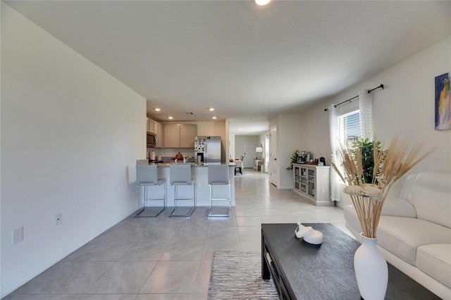 living area with baseboards, light tile patterned flooring, and recessed lighting