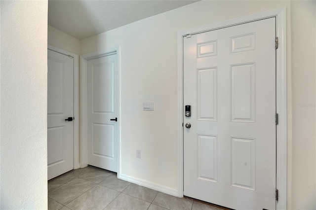 foyer entrance with baseboards and light tile patterned floors