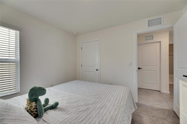 bedroom featuring light tile patterned floors, multiple windows, and visible vents