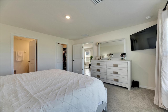 bedroom with visible vents, baseboards, a walk in closet, carpet floors, and recessed lighting