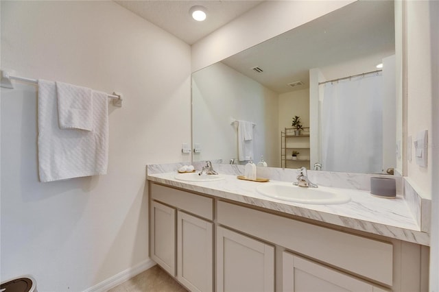 full bath with double vanity, visible vents, baseboards, and a sink