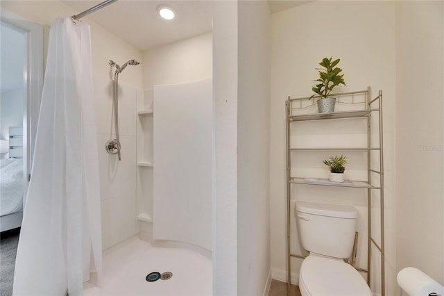 bathroom featuring toilet and a shower stall