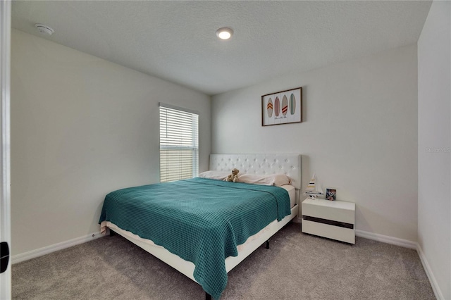 carpeted bedroom with baseboards and a textured ceiling