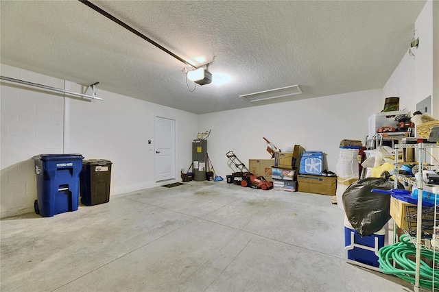 garage featuring concrete block wall, electric water heater, and a garage door opener