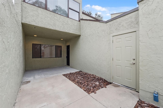 property entrance with a patio and stucco siding