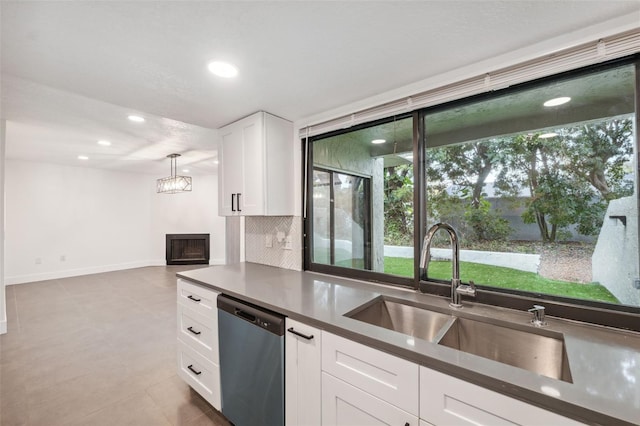 kitchen with a sink, white cabinetry, backsplash, dishwasher, and dark countertops