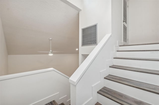 staircase with visible vents and a ceiling fan