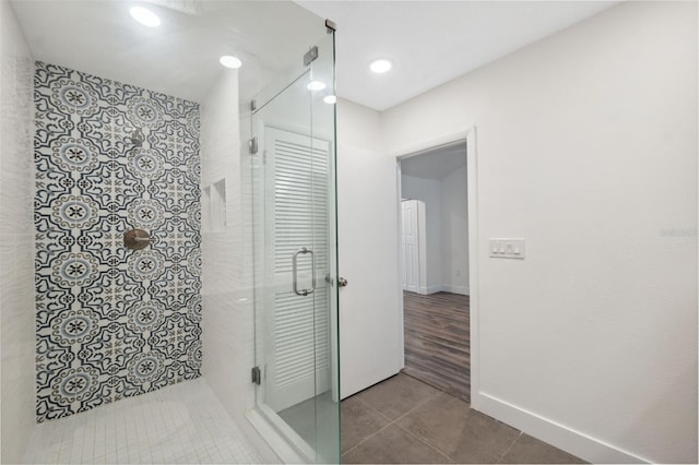 bathroom featuring recessed lighting, tiled shower, baseboards, and tile patterned floors