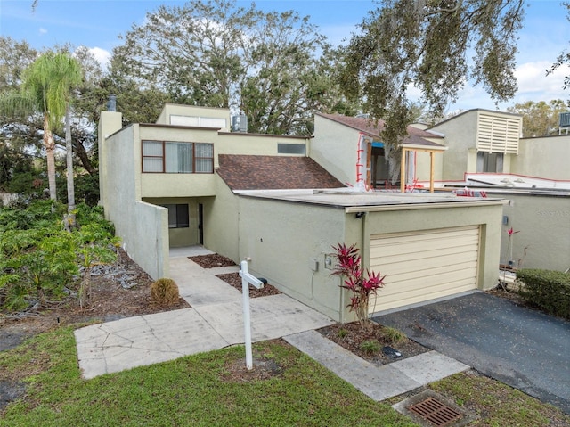 view of front of property with a garage, driveway, and stucco siding