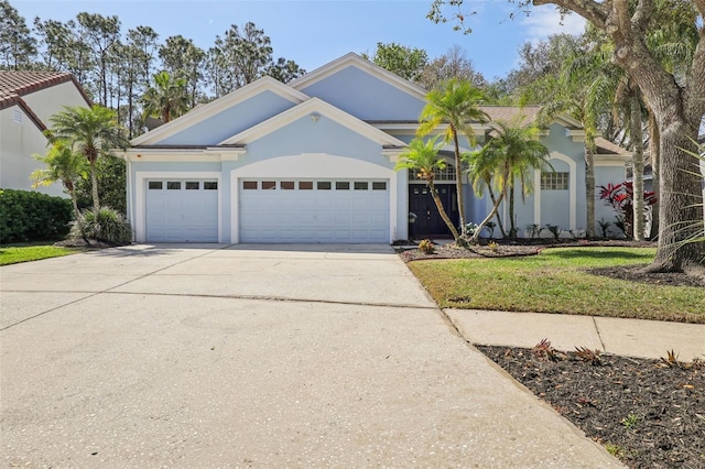 view of front of property with stucco siding, driveway, and a garage