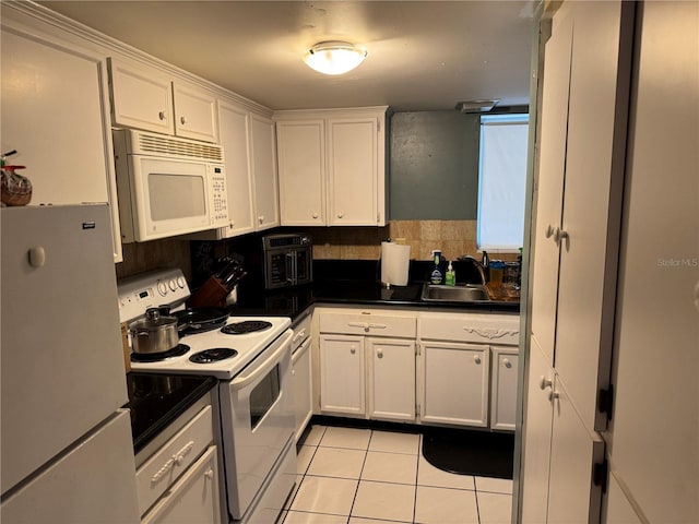 kitchen with a sink, dark countertops, white appliances, light tile patterned flooring, and white cabinets