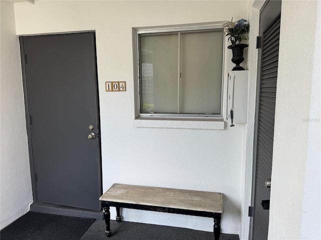 doorway to property featuring stucco siding