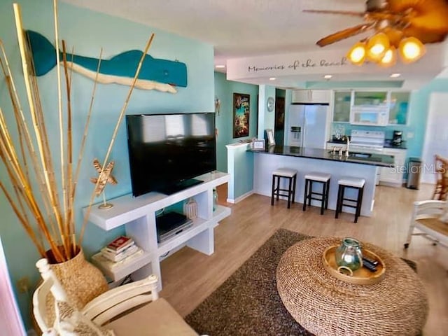 living room featuring sink, ceiling fan, and light hardwood / wood-style floors