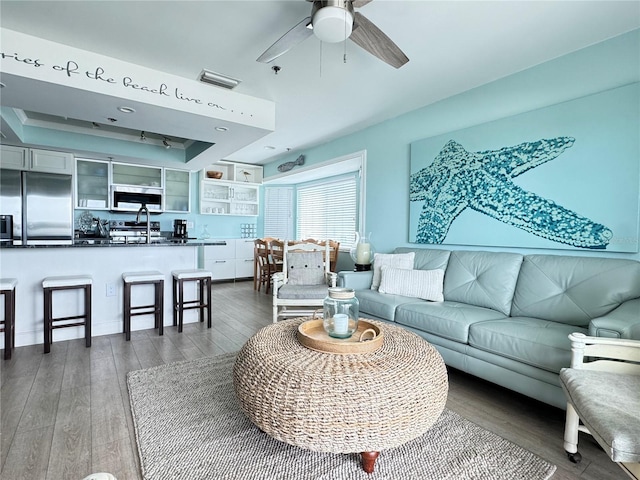 living room featuring a tray ceiling, dark hardwood / wood-style floors, and ceiling fan